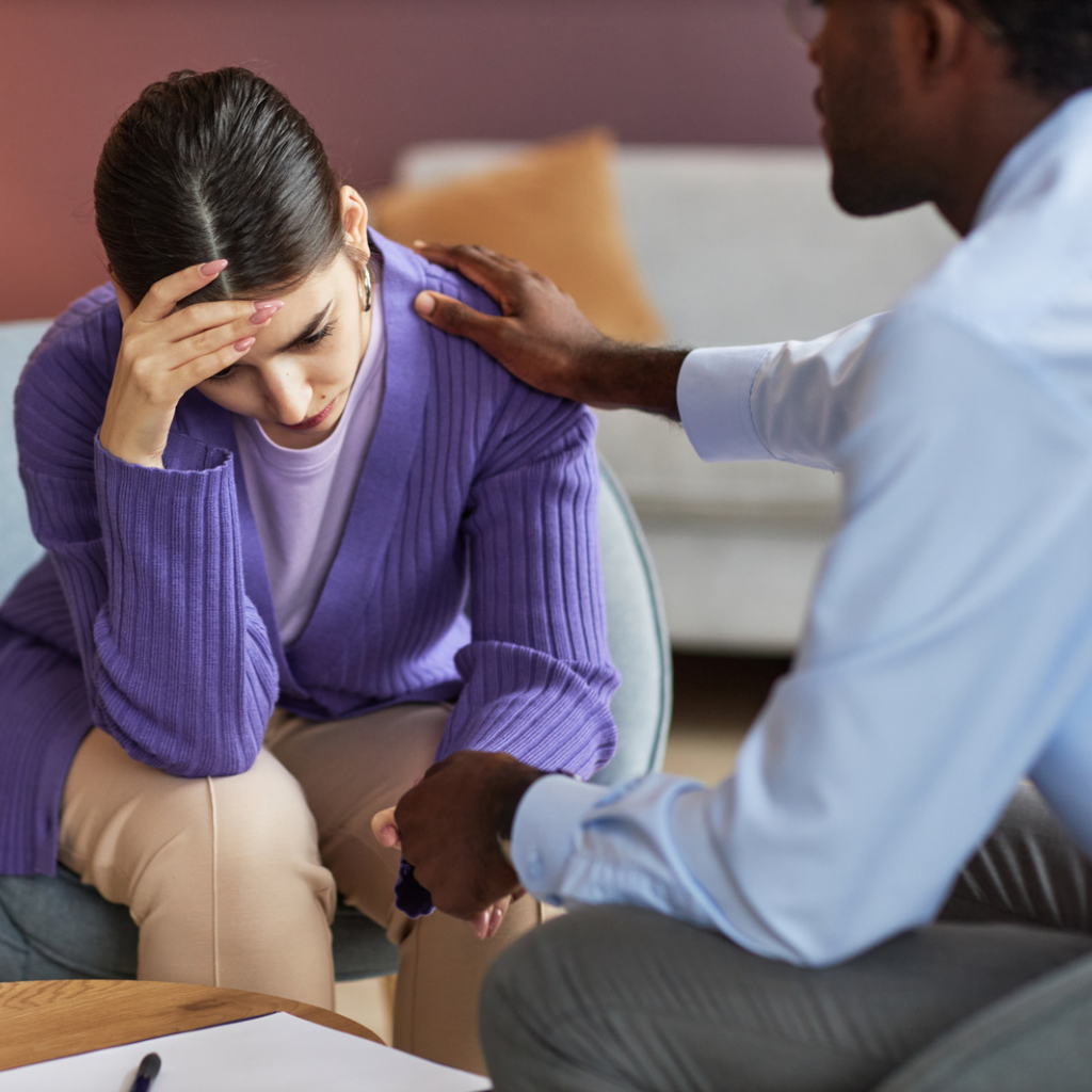 Woman looking distressed while her partner offers reassurance and emotional support, reflecting how family accommodation can develop around OCD-related anxiety.