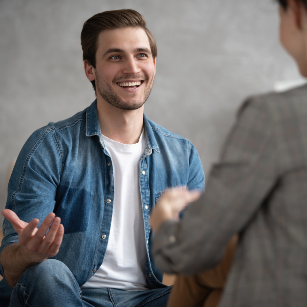 Patient speaking openly and smiling during a therapy session, reflecting trust, comfort, and a positive therapist fit.