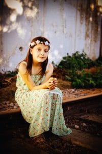 a girl sitting on a railraod