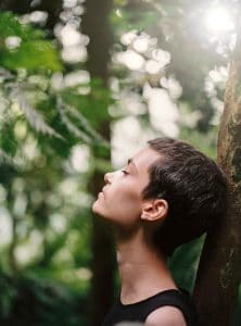 a girl leaning on a tree