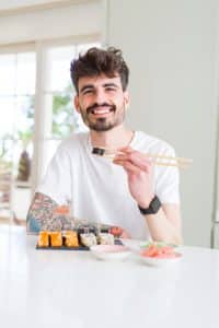 man eats sushi