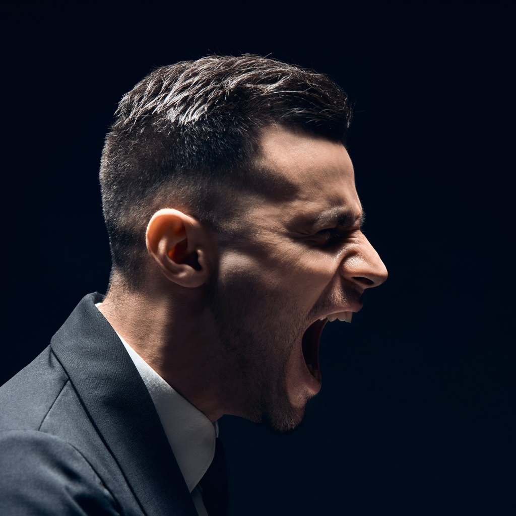 The Hidden Crisis of Male Loneliness and Depression 2 A man in a suit yelling, reflecting emotional distress linked to male loneliness and depression.