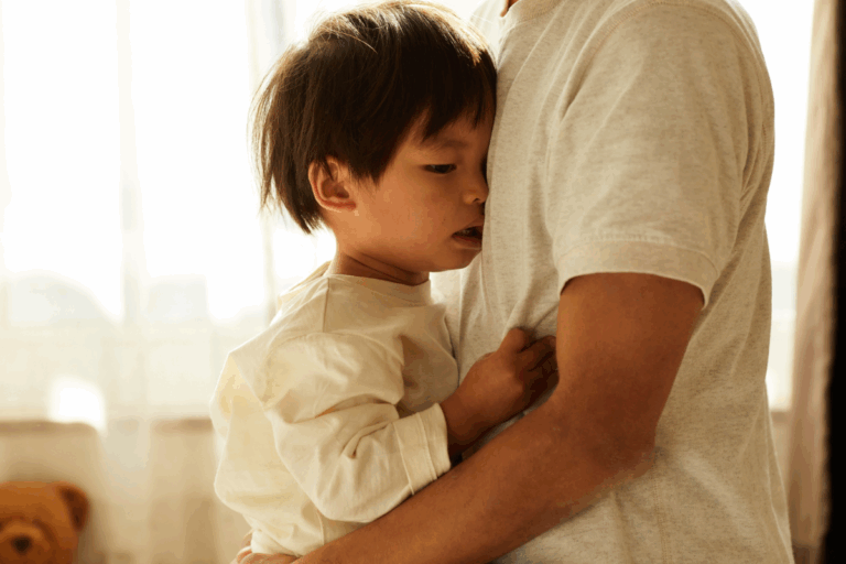 A young child clings to a parent for comfort, showing signs of fear or anxiety.