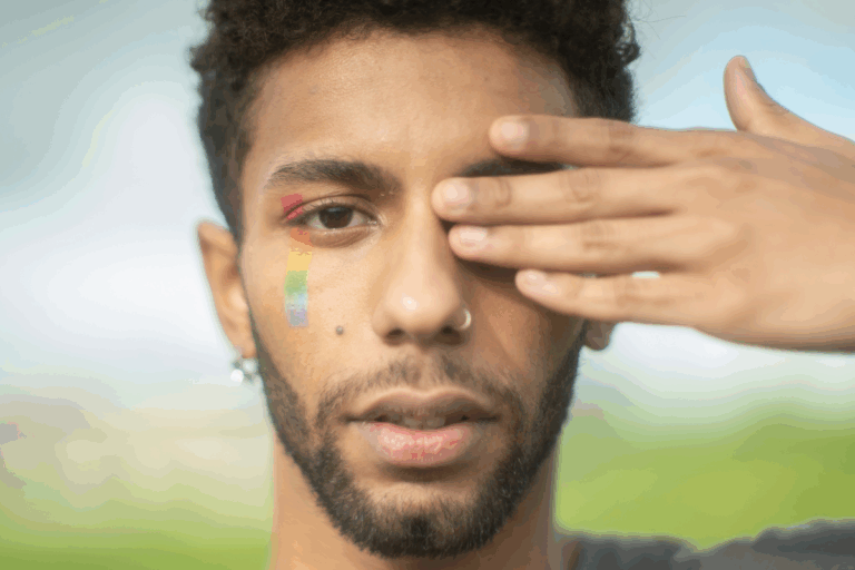 Person with rainbow face paint showing LGBTQ+ pride