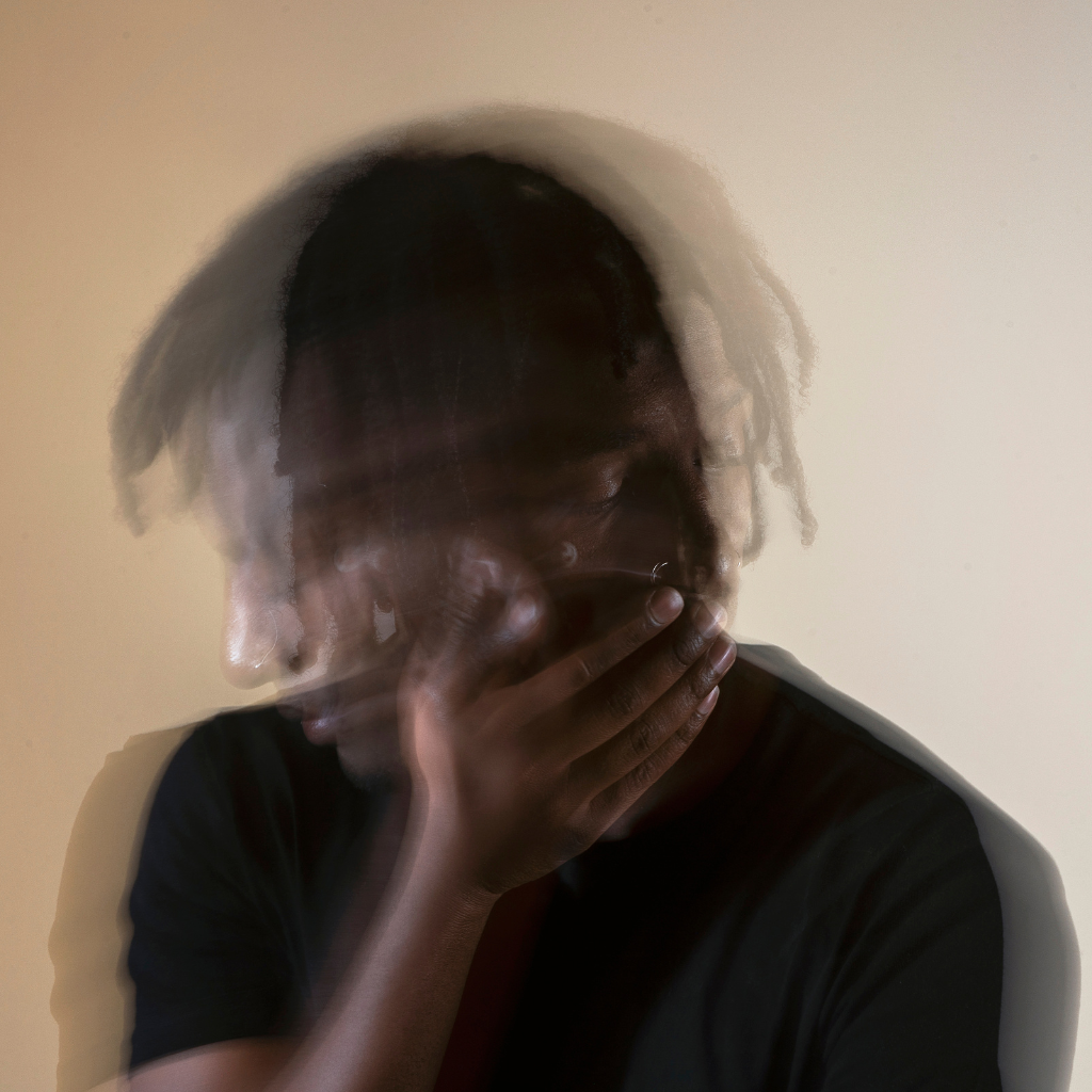 OCD vs. ADHD: Intersection of Symptoms and Strategies 1 Blurred image of a distressed man holding his face, showing the mental confusion and overlapping symptoms of OCD and ADHD.