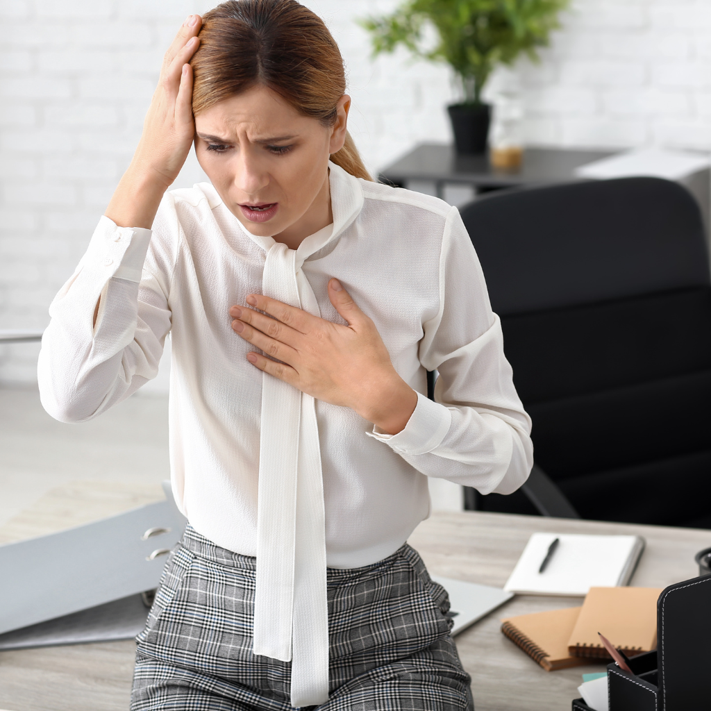 What Are Anxiety Disorders and What Causes Them? 1 A woman experiencing a racing heart and distress at work, showing how anxiety can disrupt daily life.