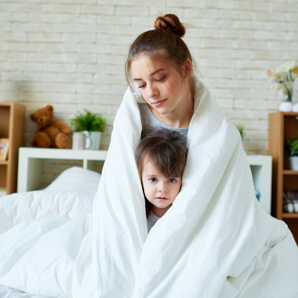The Role of Parenting in Addressing Fears and Phobias in Children 2 Mother and child wrapped in a blanket, symbolizing comfort, safety, and parental support in managing childhood fears.