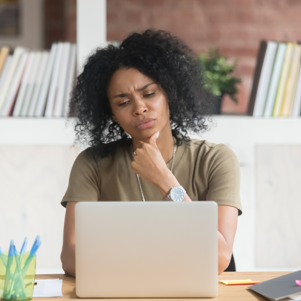 Depression Treatment Simplified: How LAIs and TMS Reduce the Burden of Daily Medications 2 Woman thoughtfully looking at her laptop while considering treatment options.