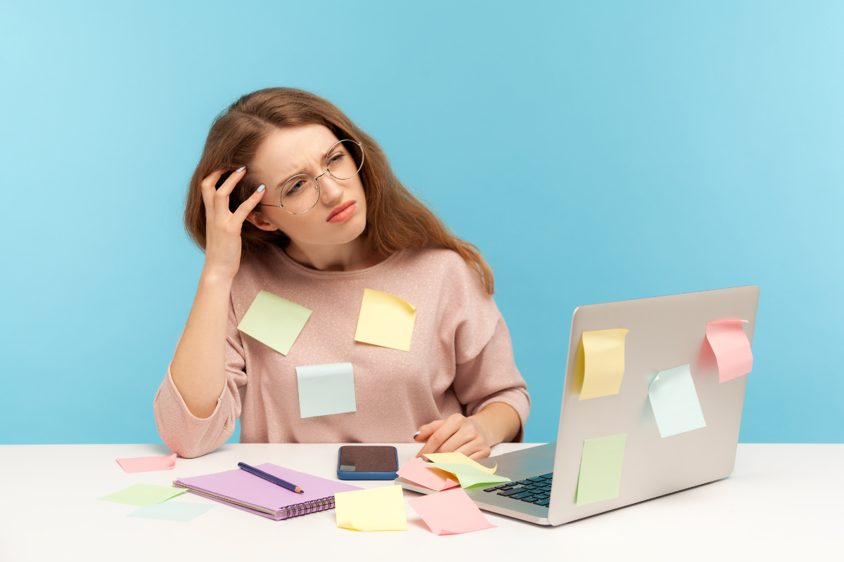 Distracted woman at desk, representing inattentive symptoms linked to ADHD and ADD.