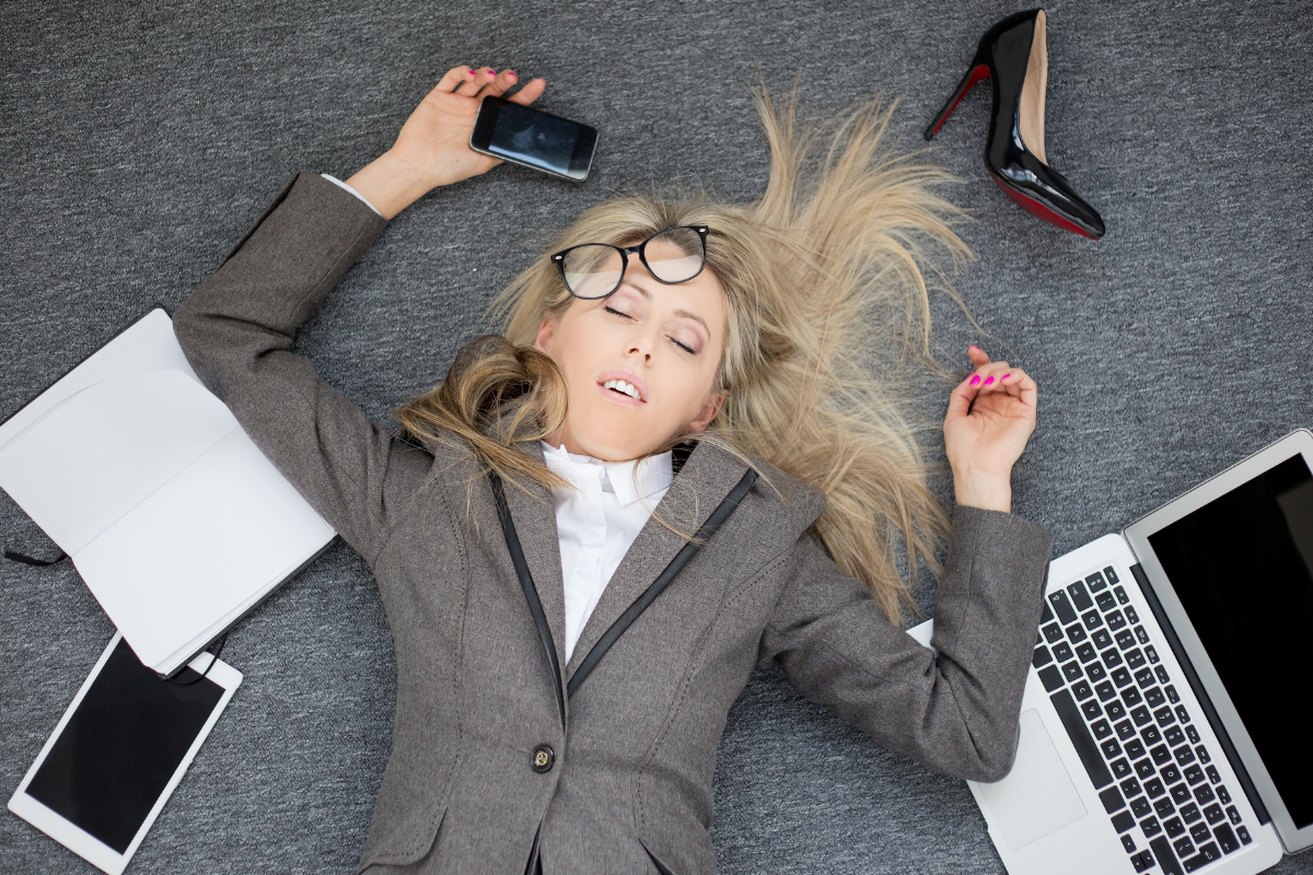 Woman experiencing ADHD burnout, surrounded by work items