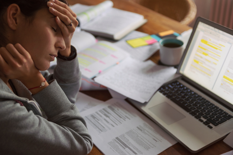 Woman overwhelmed at her desk, showing signs of ADHD burnout and mental fatigue.