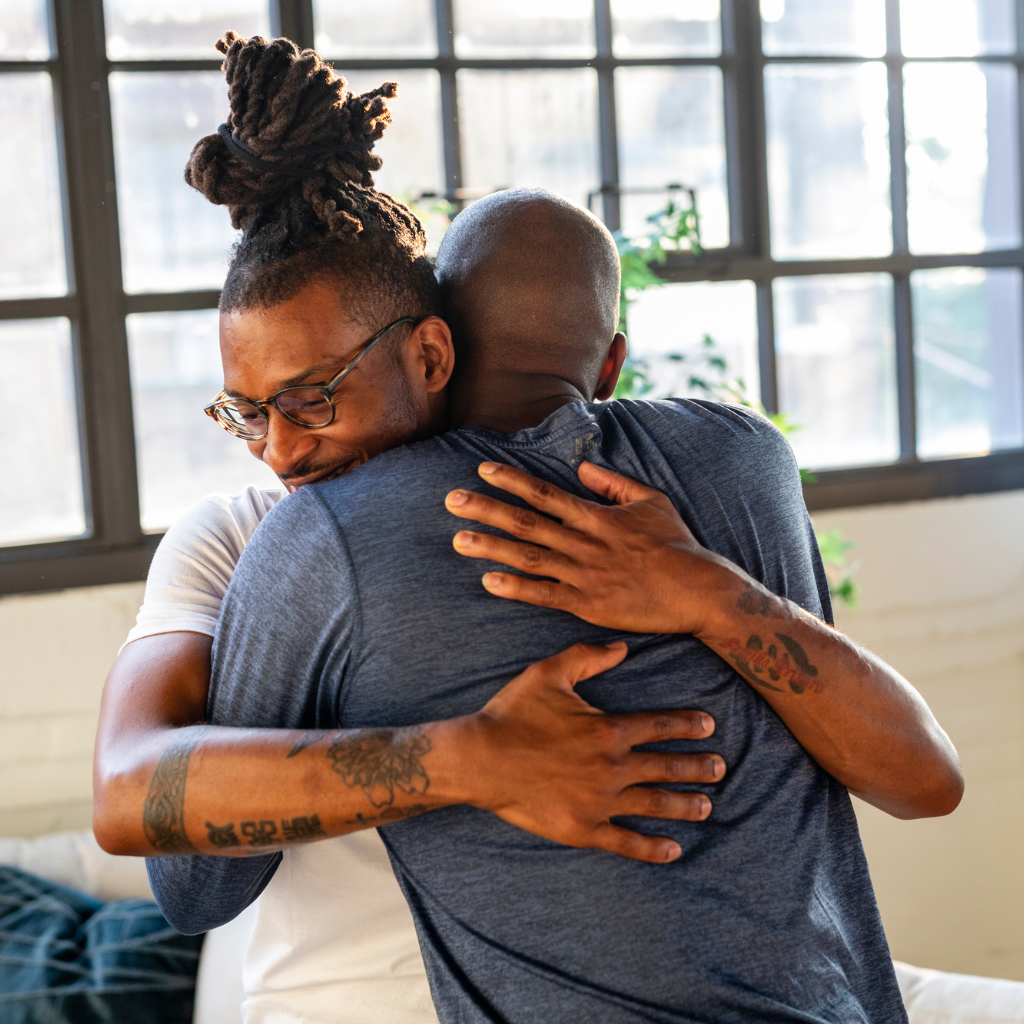 Pride Month: Addressing Mental Health Challenges in the LGBTQIA+ Community 2 Two friends hugging, showing support and connection in the LGBTQIA+ community.