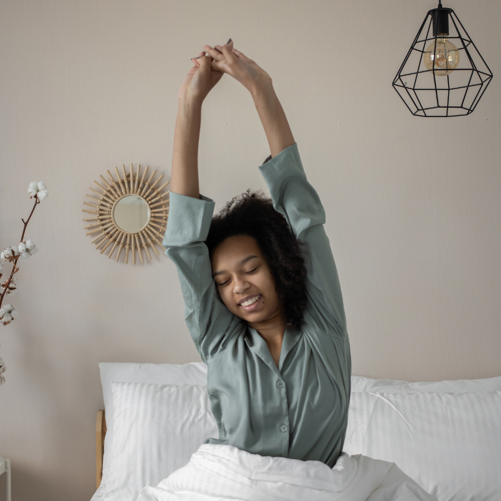 CBT for Intrusive Thoughts: Rewiring Your Mind 2 Woman waking up and stretching, supporting better sleep for mental health.