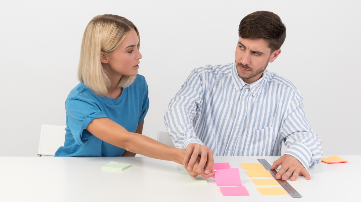 Man reacting as woman disrupts his organized notes, highlighting OCD behavior.