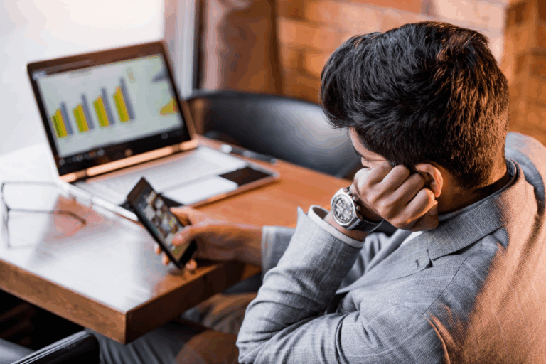 Man looking at his phone, procrastinating instead of working.