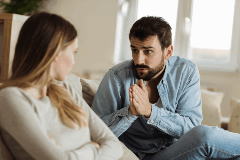 Man pleading with woman during tense conversation, reflecting conflict and emotional imbalance in a codependent relationship.