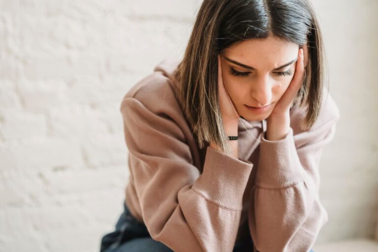 Woman feeling overwhelmed and doubtful, a common experience with imposter syndrome.