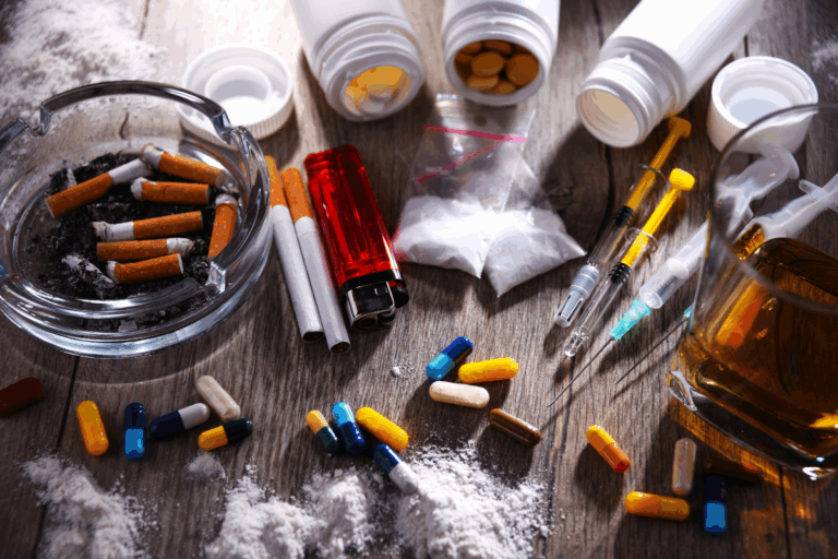 Drugs, pills, alcohol, and syringes symbolizing substance use disorder.
