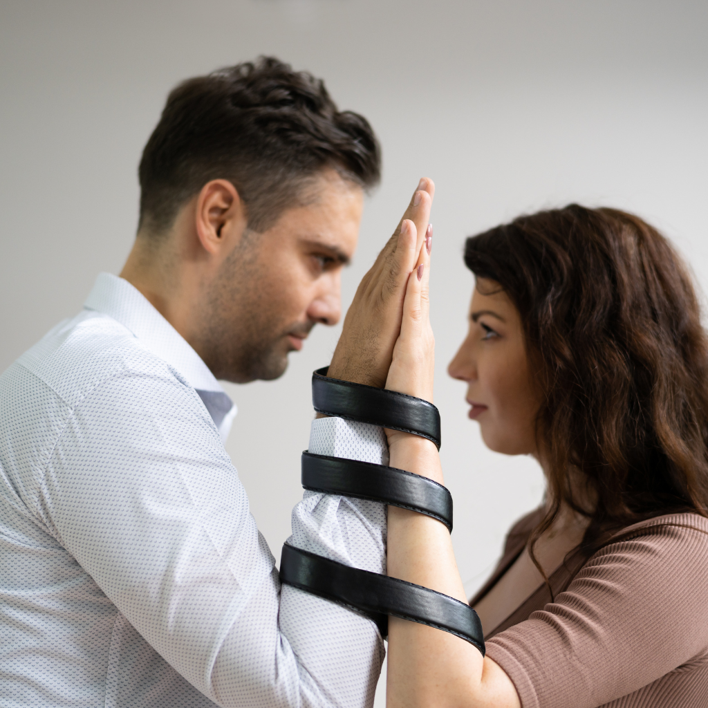 Man and woman with their arms tied together, representing a codependent relationship.
