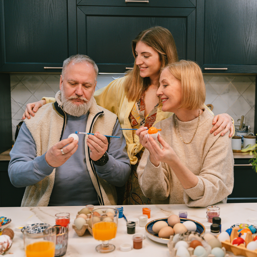 Happy family painting Easter eggs together as part of engaging in meaningful activities, a core principle of Behavioral Activation Therapy.
