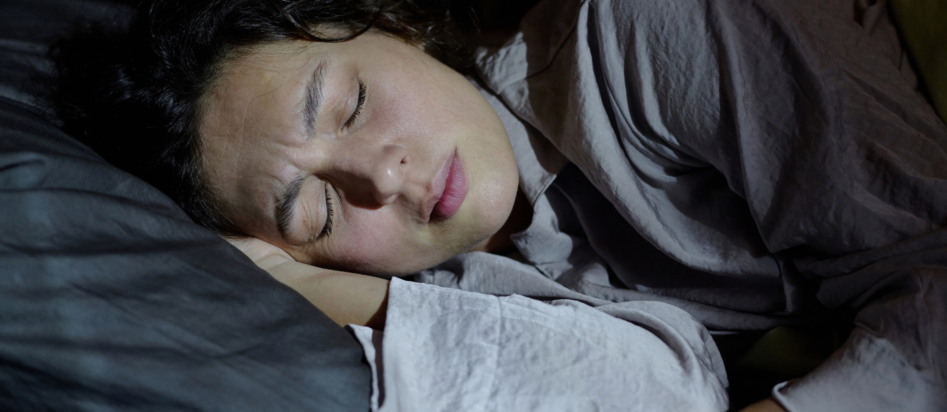 Person experiencing restless sleep linked to REM Sleep Behavior Disorder.