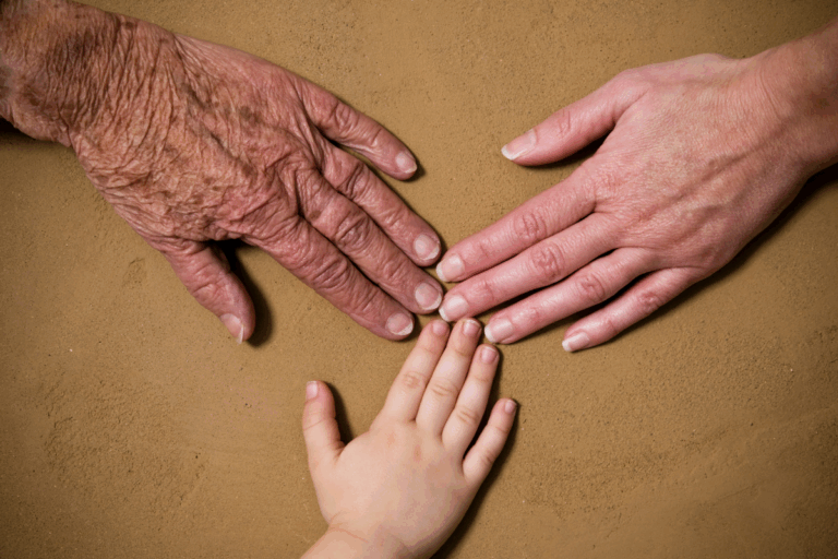 Grandparent, parent, and child hands representing generational trauma.