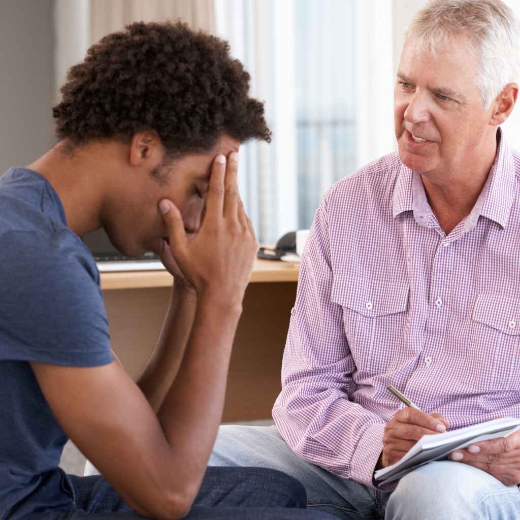 Man with dysthymia talking to therapist during a counseling session for persistent depressive disorder treatment.
