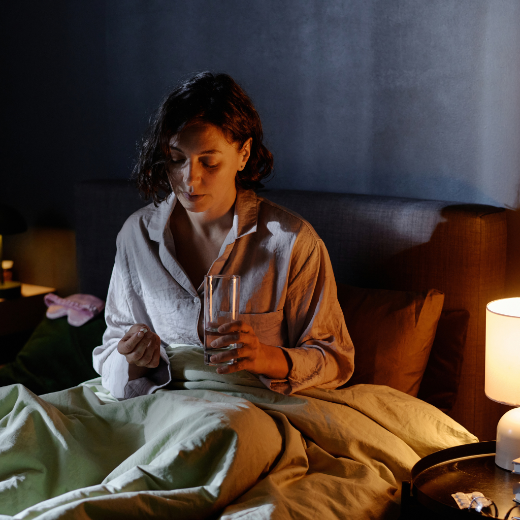 Woman with REM Sleep Behavior Disorder taking medication at night as part of treatment.