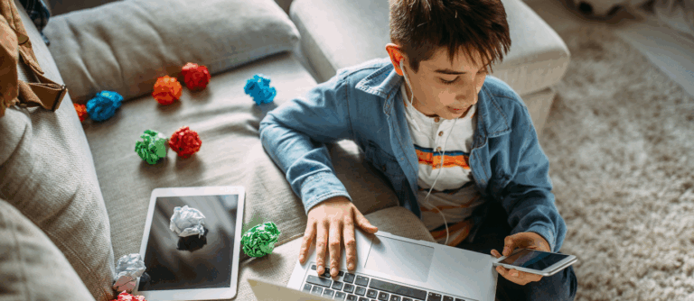 Teen using smartphone and laptop, symbolizing adolescent anxiety and social media use.