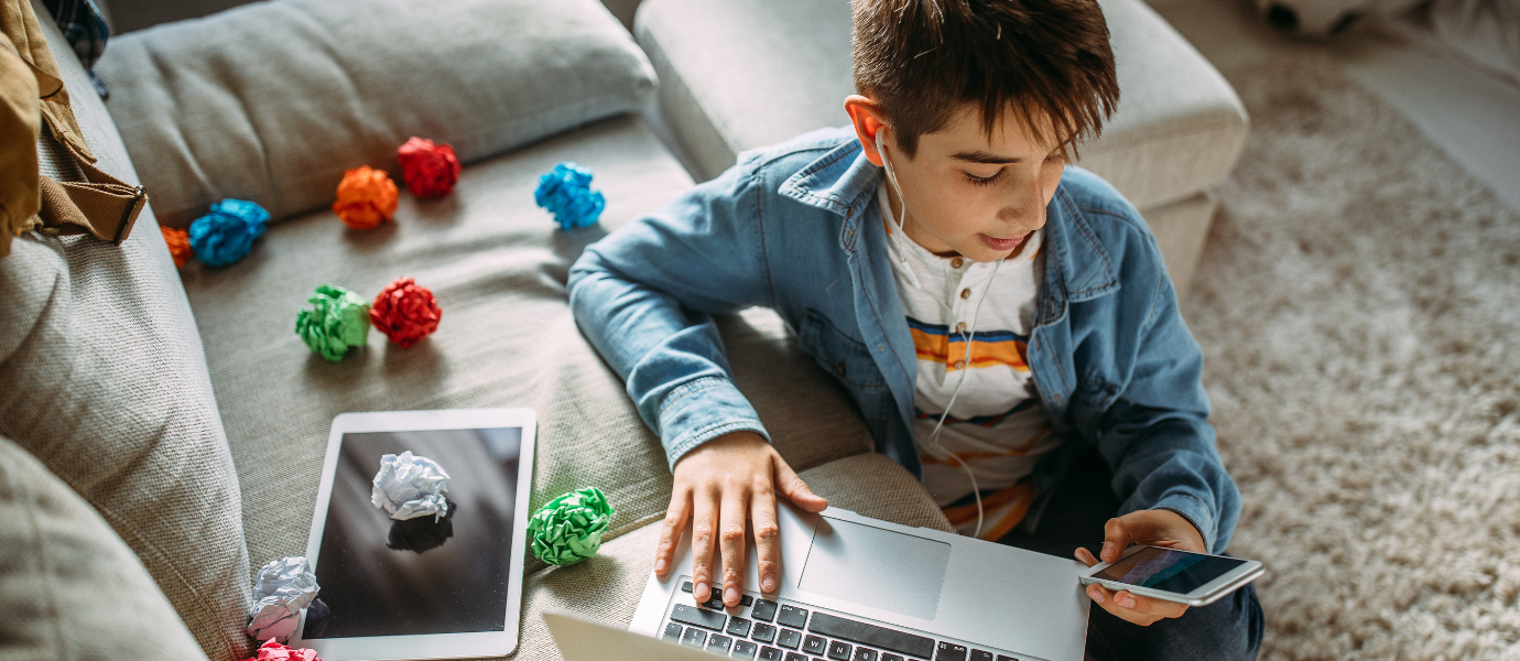 Teen using smartphone and laptop, symbolizing adolescent anxiety and social media use.