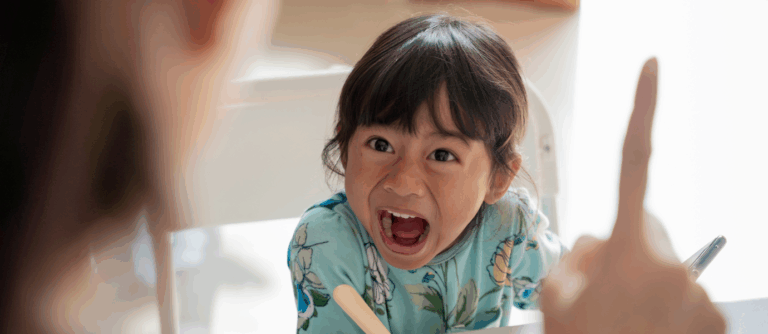 A young child showing defiant behavior during a conversation with a parent, illustrating Oppositional Defiant Disorder in children.