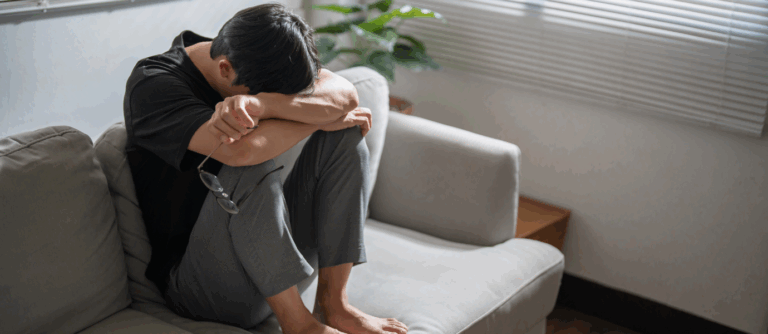 Person sitting on a couch, feeling sad or distressed showing signs of Major Depression Disorder
