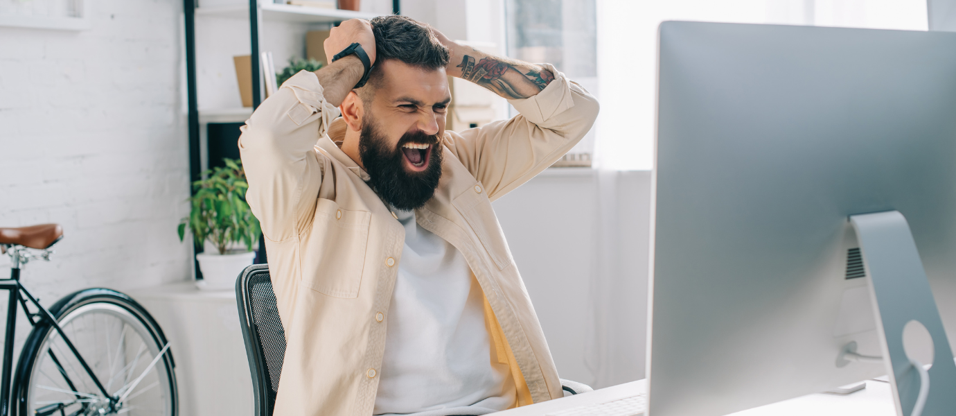 Man showing frustration and distraction at work, reflecting ADHD in men.