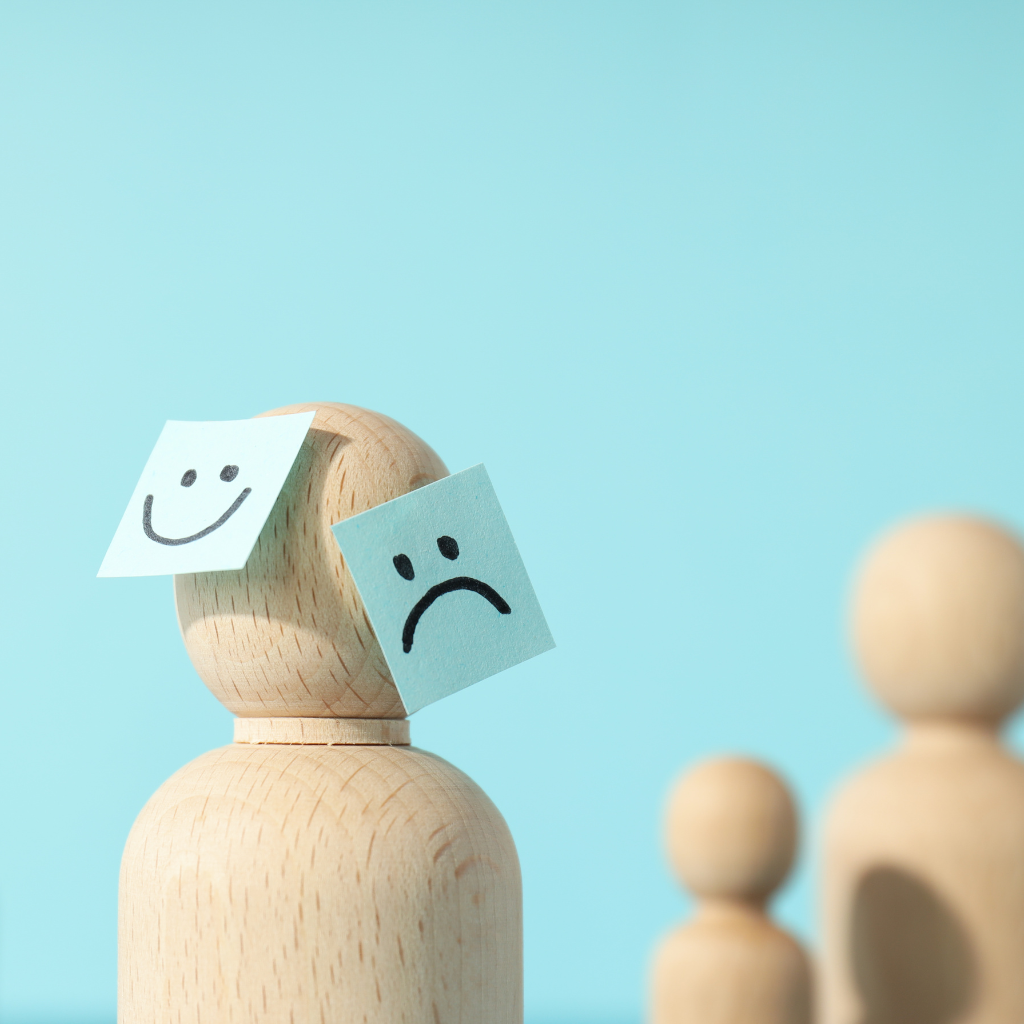Wooden figure showing emotional states in mental health care.