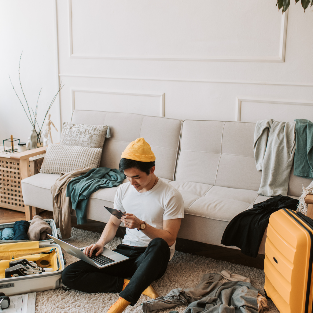 ADHD in Men: Symptoms, Causes & Treatment Approaches 1 Man sitting in a cluttered room with a laptop, showing common signs of disorganization linked to ADHD in men.