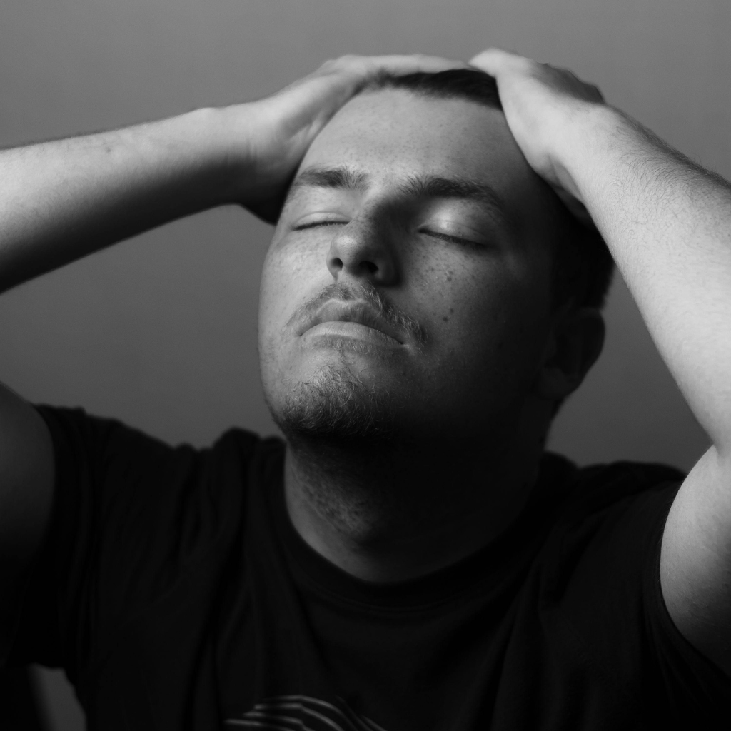 Man holding his head in distress, showing the struggle of disorganized or racing thoughts.