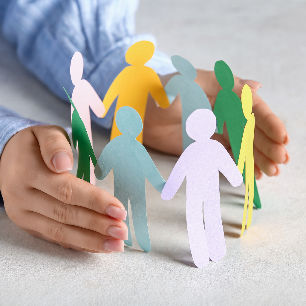 Hands holding a circle of colorful paper cutout figures, symbolizing collaboration and integrated care.