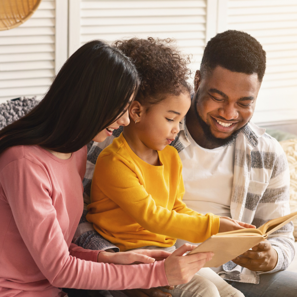 Parents spending a calm moment reading with their child, creating a supportive and relaxed home environment.