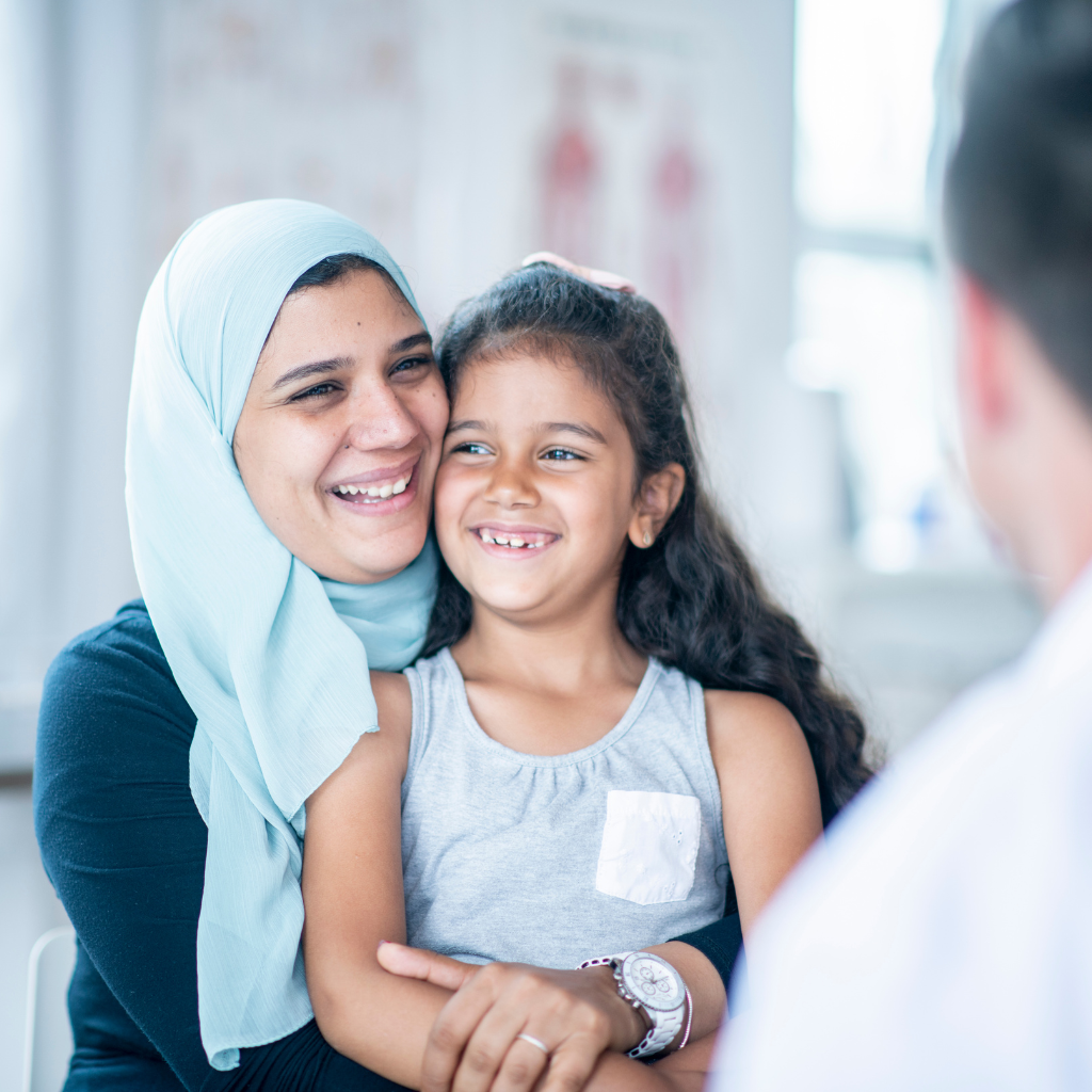 A mother and child smiling together while receiving supportive mental health care.