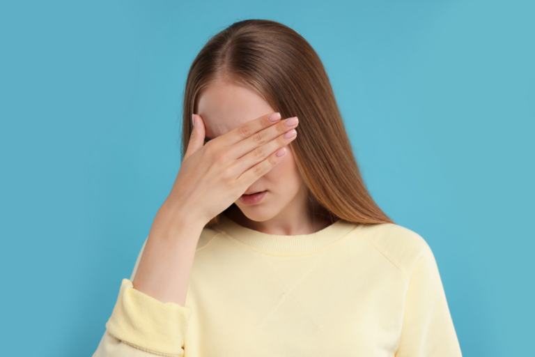 Woman covering her face, representing emotional exhaustion and the hidden effort of ADHD masking