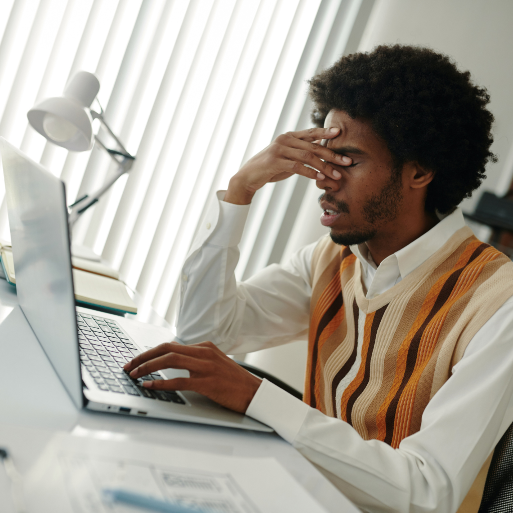 Man experiencing mental exhaustion while working at a computer, representing the emotional cost of ADHD masking