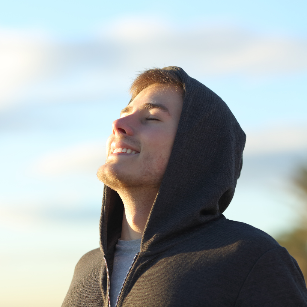 Person taking a calm breath outdoors, practicing grounding during anxiety