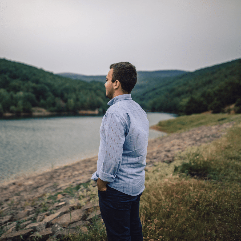 a man gazing at a landscape with withdrawn posture symbolizing emotional disconnection and anhedonia