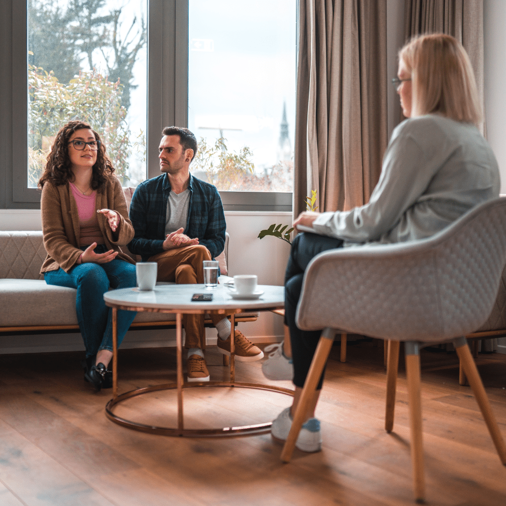 Couple speaking with a therapist during a counseling session, representing professional support for ADHD-related relationship challenges.