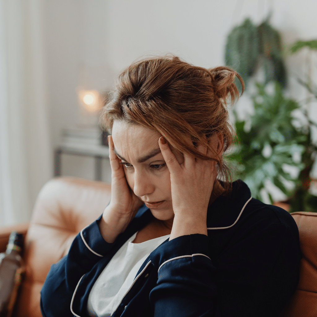 Understanding Psychomotor Retardation in Depression 1 Woman holding her head with reduced movement and slowed body language, representing depressive psychomotor slowing.