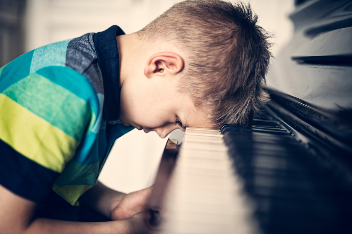 Child resting head on piano, showing emotional distress linked to anxiety and depression in children
