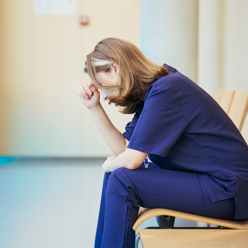 What Is Secondary Traumatic Stress — And Could It Be Happening to You? 1 Clinician seated with bowed posture, representing compassion fatigue and vicarious trauma.