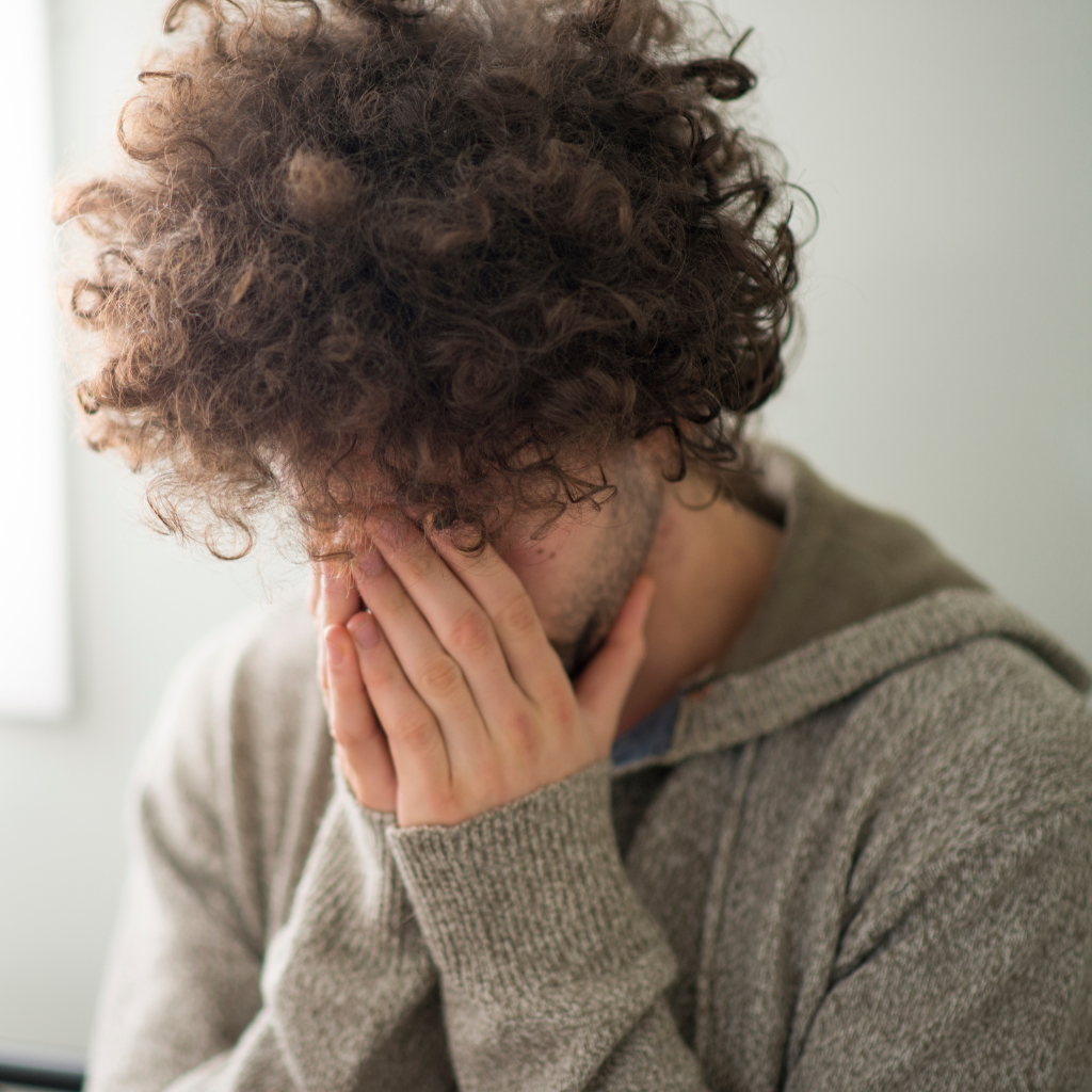 Man overwhelmed by worry about illness, a common sign of health anxiety.