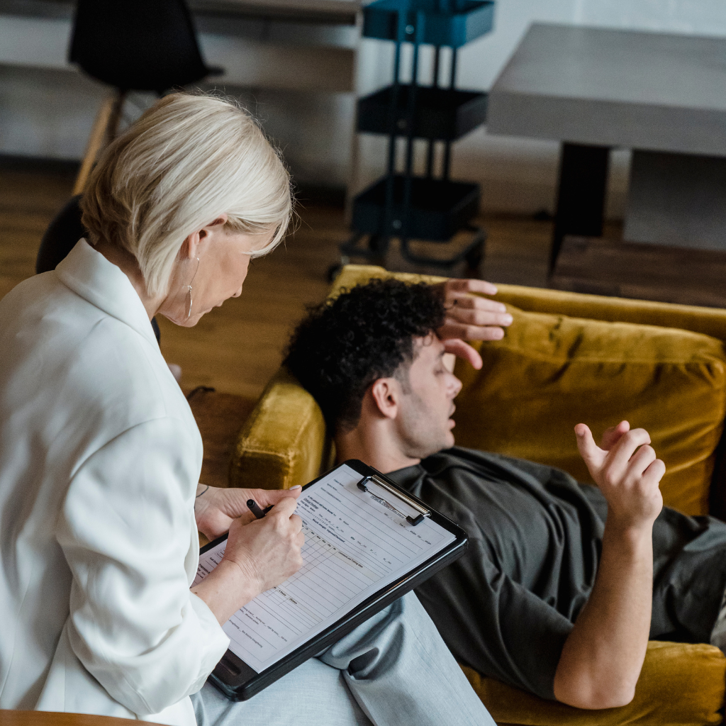 Therapist taking notes while patient discusses anxiety during exposure-based treatment.