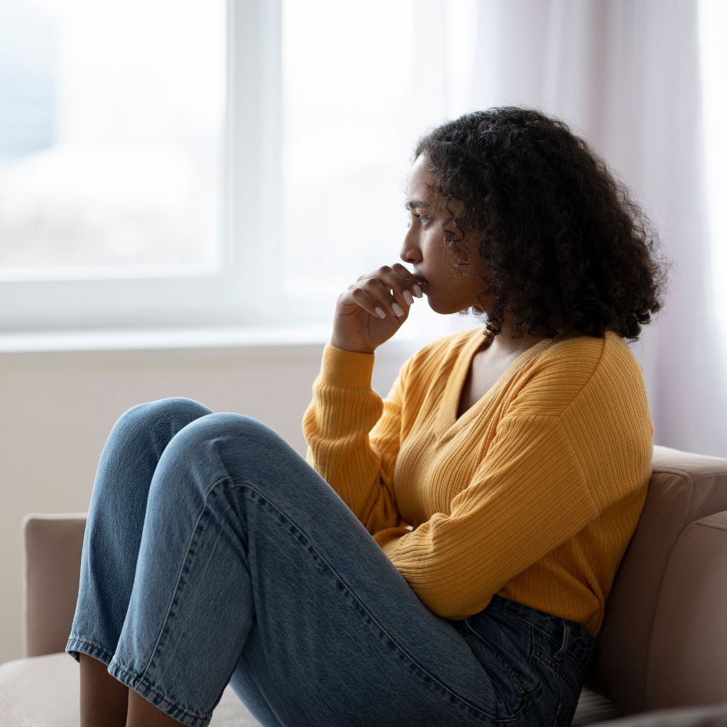 Person sitting alone by a window, showing isolation from PTSD and depression